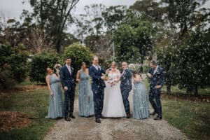 Aleisha, Mitchell and their bridal party celebrating with champagne on the gravel path at Growwild Wildflower Farm.