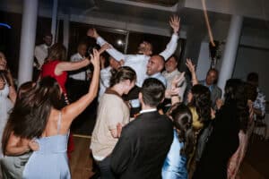 Groom Nick being lifted into the air by cheering guests on the dancefloor during an epic wedding reception party hosted by Unity Entertainment.