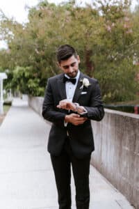 Groom Nick smiling in his sharp suit from Kelly Country on his wedding day.