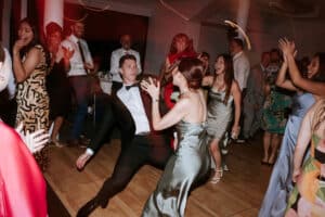 Wedding guests jumping and dancing on a packed dancefloor at San Martin Akuna Bay while Unity Entertainment DJ plays party anthems.