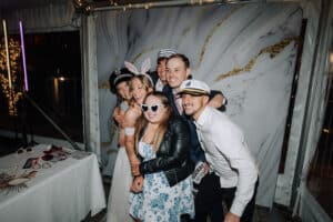 Wedding guests posing with props in the Growwild photo booth at Aleisha and Mitchell's reception.